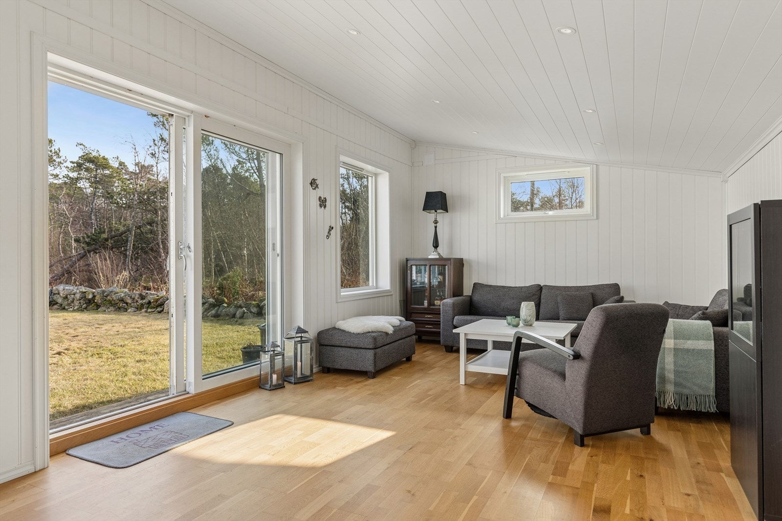 Store vinduer og skyvedør gir direkte utgang til hagen. Galleribilde