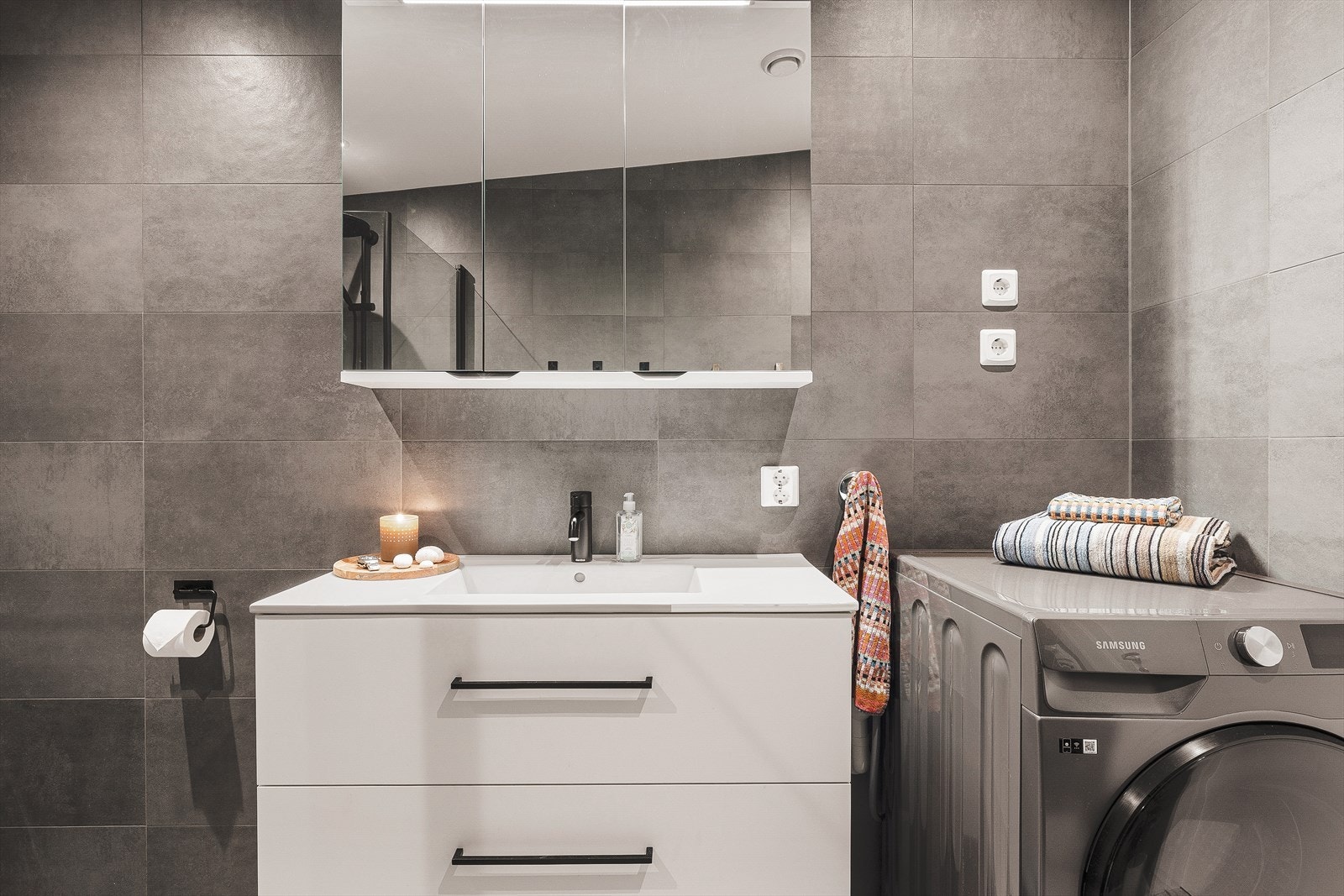 Her får du en praktisk servantløsning med møblement og speil, i tillegg til opplegg for vaskemaskin og tørketrommel. Galleribilde