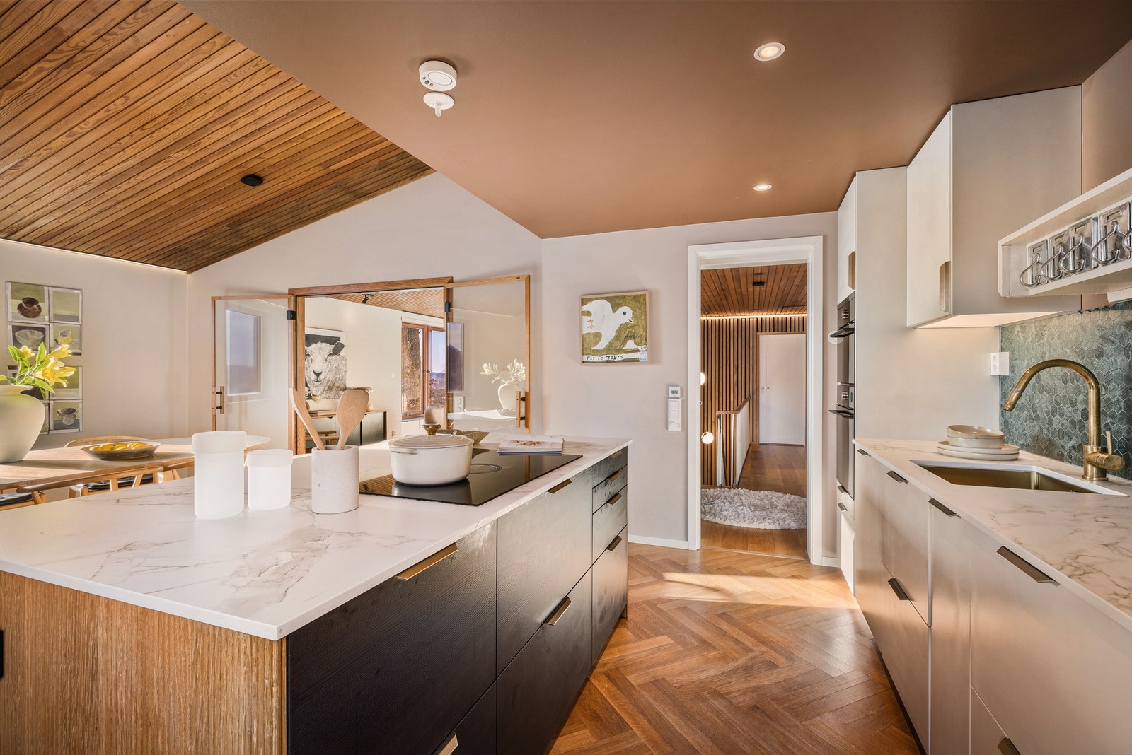 Kjøkkenøyen med eikespiler er nøye utvalgt for å spille på treelementene ellers i boligen - Studio Homes har bistått med interiørdesign for renoveringen Galleribilde