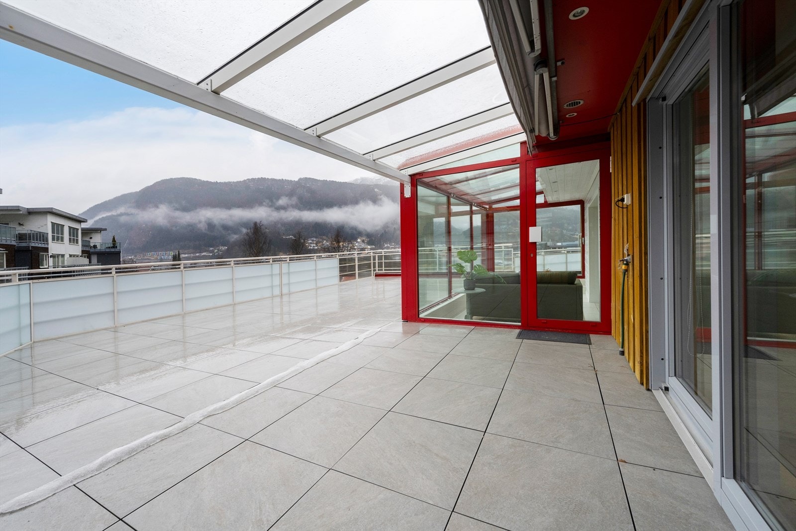 Terrassen har flislagt dekke og praktiske takoverbygg. Legg merke til markisa, vass- og straumuttaka. Galleribilde