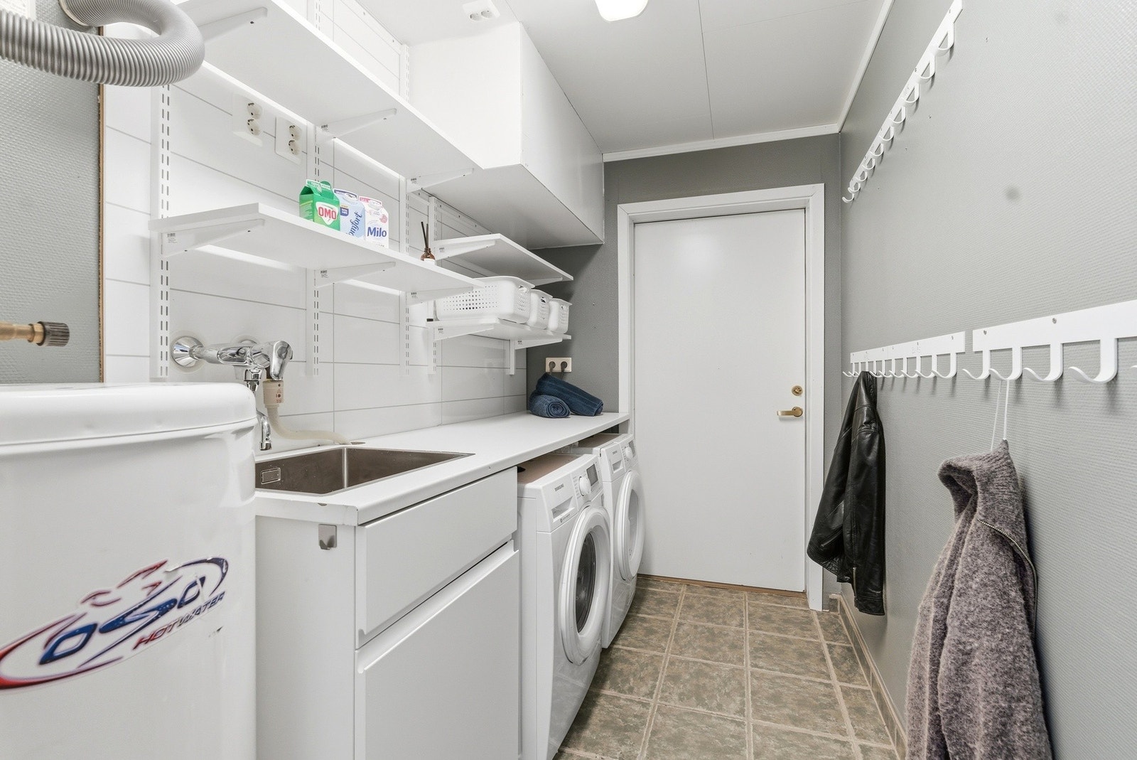 Vaskerommet har flislagt gulv med varmekabler. Dør inn til meget stor og praktisk innebod. Galleribilde