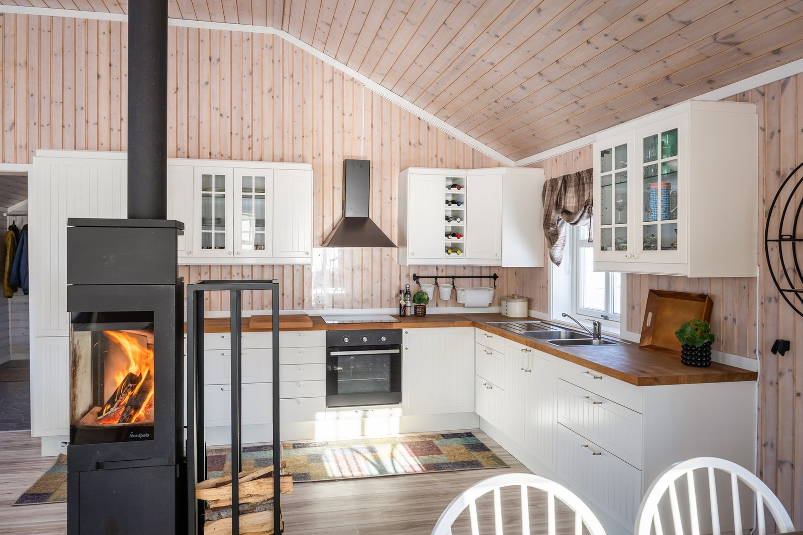 Stilren og klassisk kjøkkeninnredning i hvit utførelse, med benkeplate i heltre. Galleribilde