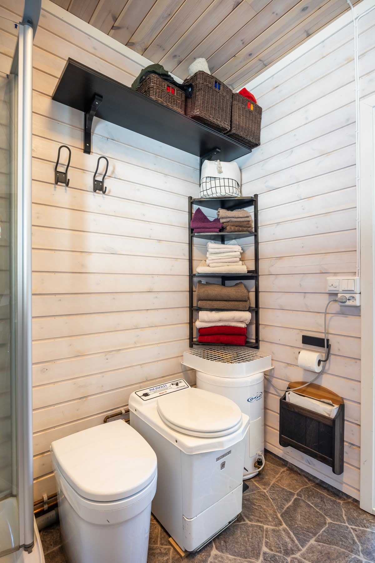 Badet er utstyrt med dusjkabinett, forbrenningstoalett, innredning med servant og opplegg for vaskemaskin. Galleribilde