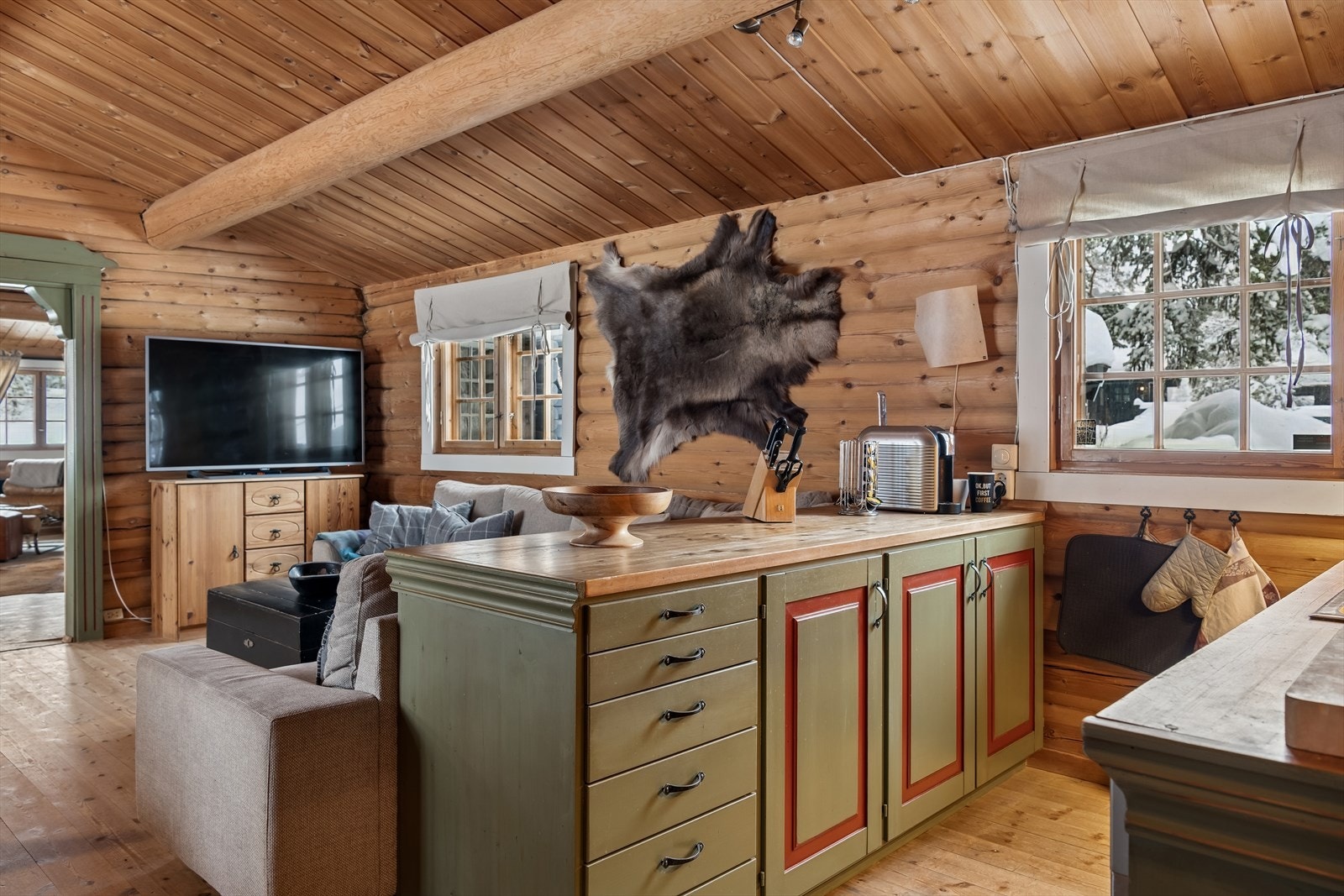 En praktisk kjøkkenøy gir ekstra oppbevaringsplass samtidig som et lite skille mot TV-kroken. Galleribilde