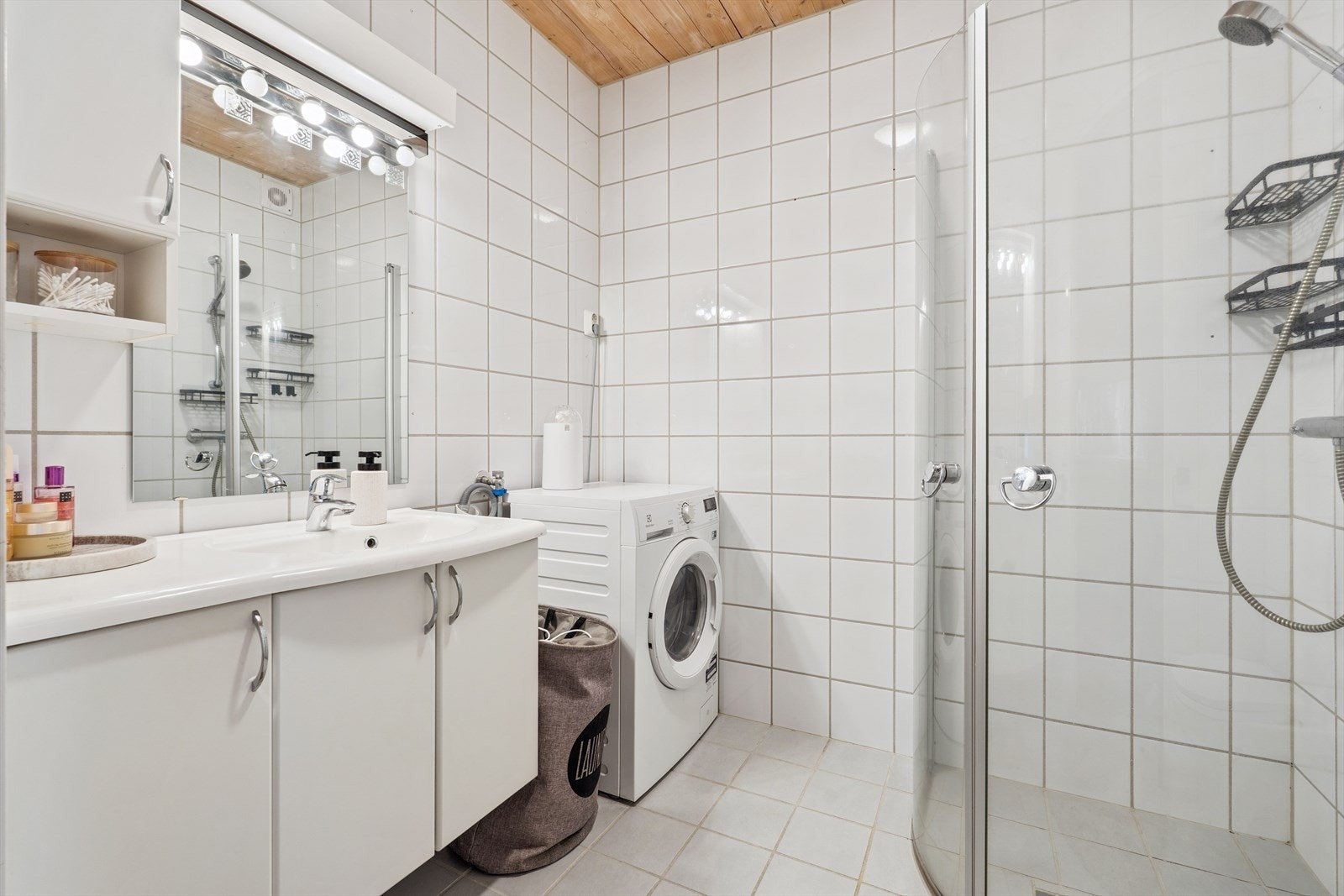 Flislagt bad/wc med dusjhjørne, innredning og opplegg for vaskemaskin. Galleribilde