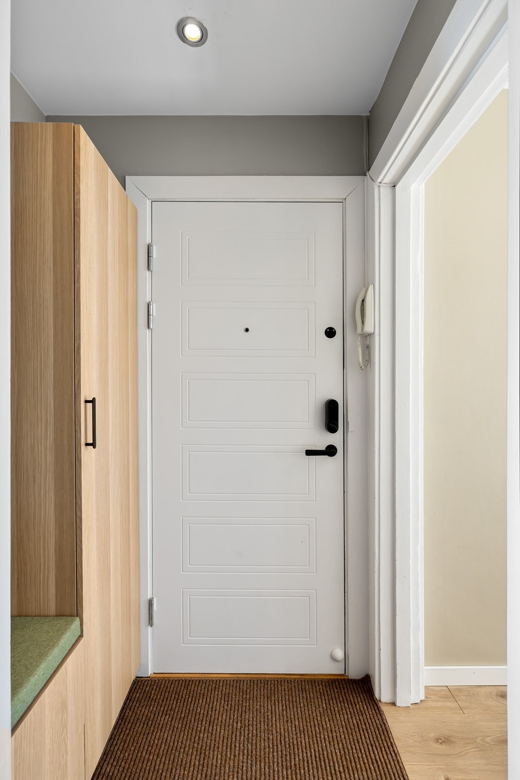 Lys og innbydende entré som ble modernisert i 2025.Entréen har Yale Doorman smartdørlås og nytt svart dørhåndtak. Galleribilde