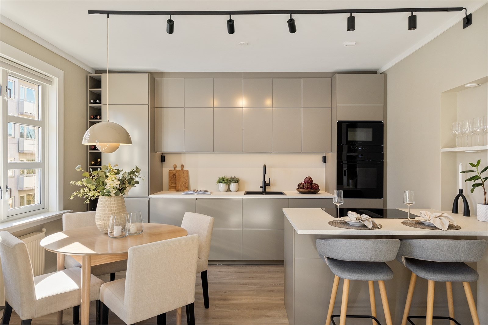 Stilrent kjøkken fra 2024 med glatte fronter, god skap og skuffeplass samt god plass på benkeplaten til matlaging. Galleribilde