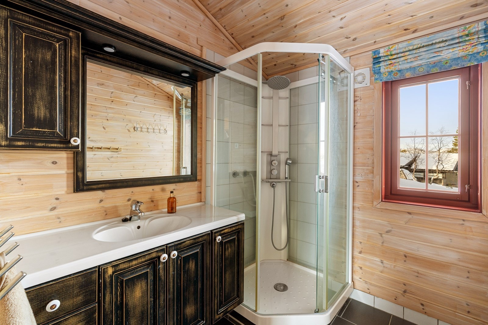 Badet er utstyrt med dusjkabinett og innredning med nedfelt servant. Galleribilde