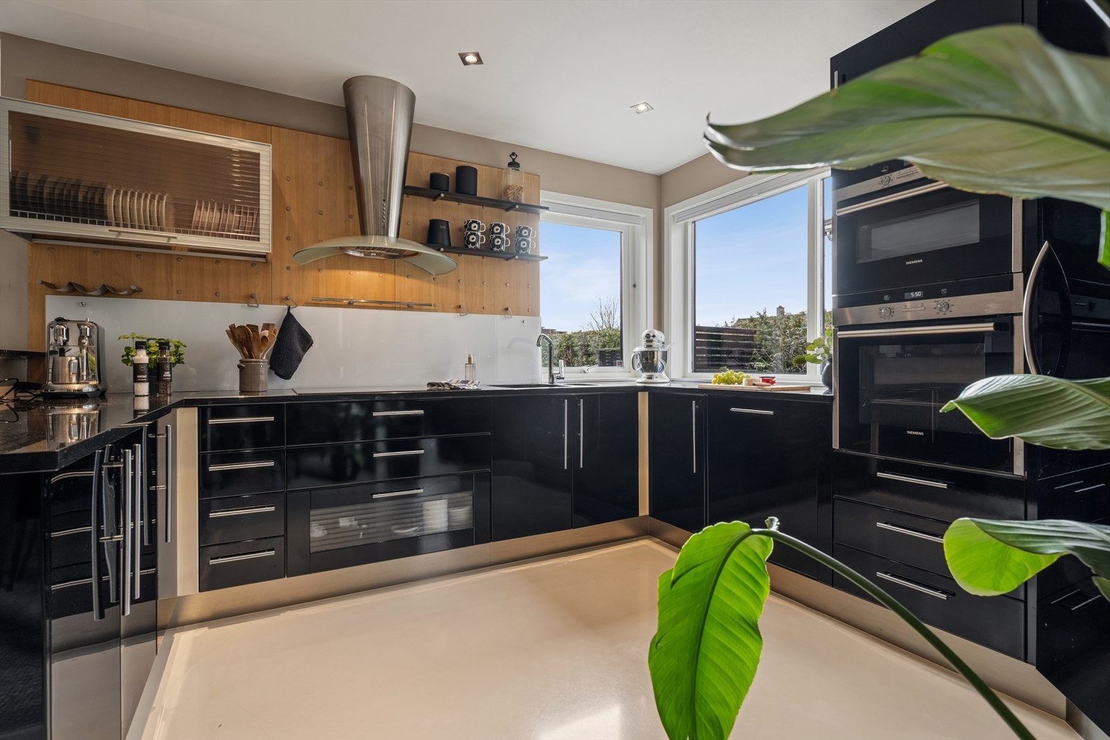 Stilig kjøkken med sorte fronter i U-form. Galleribilde