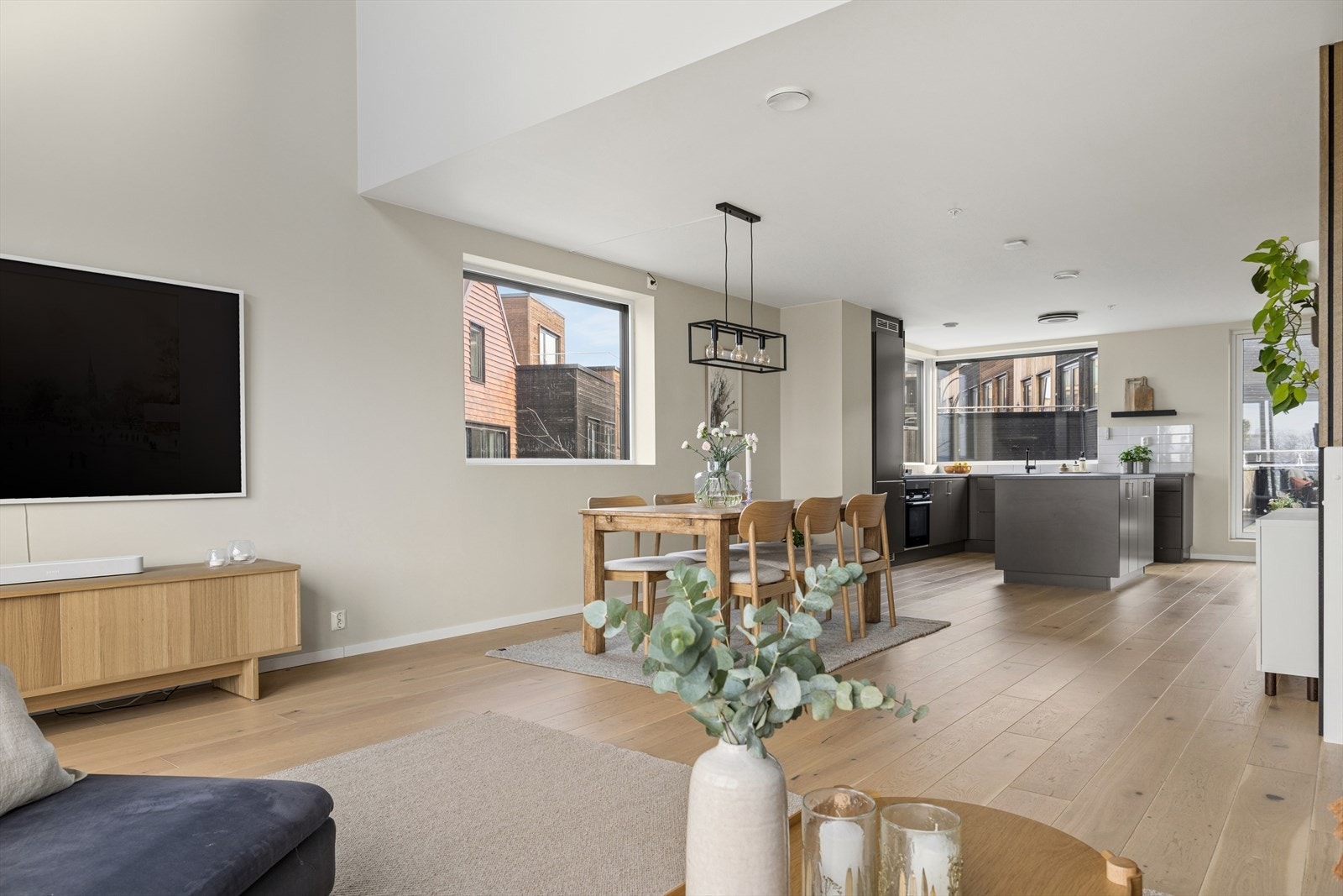 Den åpne løsningen gir en luftig atmosfære og en naturlig flyt mellom kjøkken, spisestue og stue. Store vindusflater på 3 sider av bygget gir også godt gjennomlys. Galleribilde