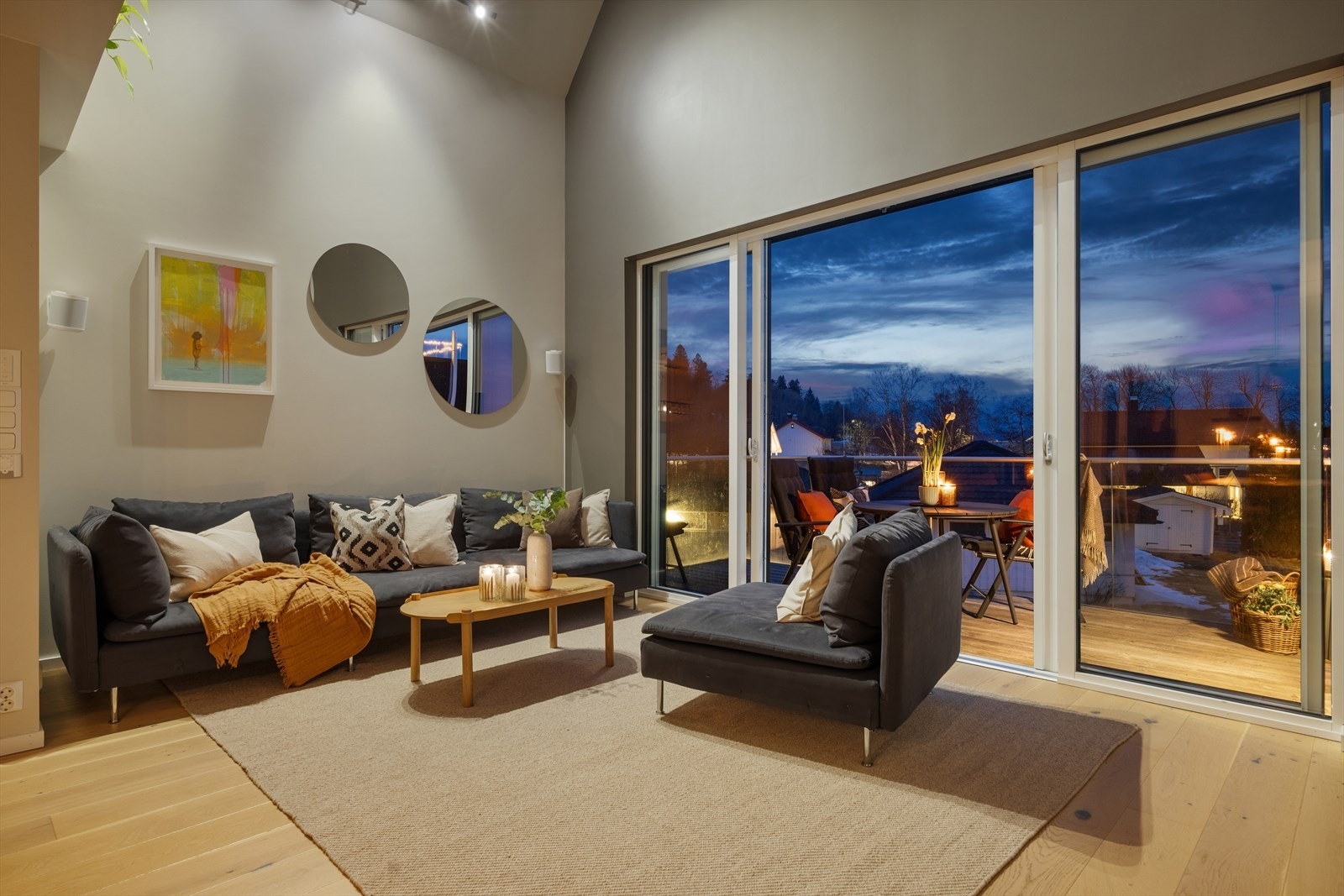På kveldstid skaper belysningen og de store vinduene en stemningsfull atmosfære. Her er det god plass til en romslig sofagruppe for avslapning og hygge. Galleribilde