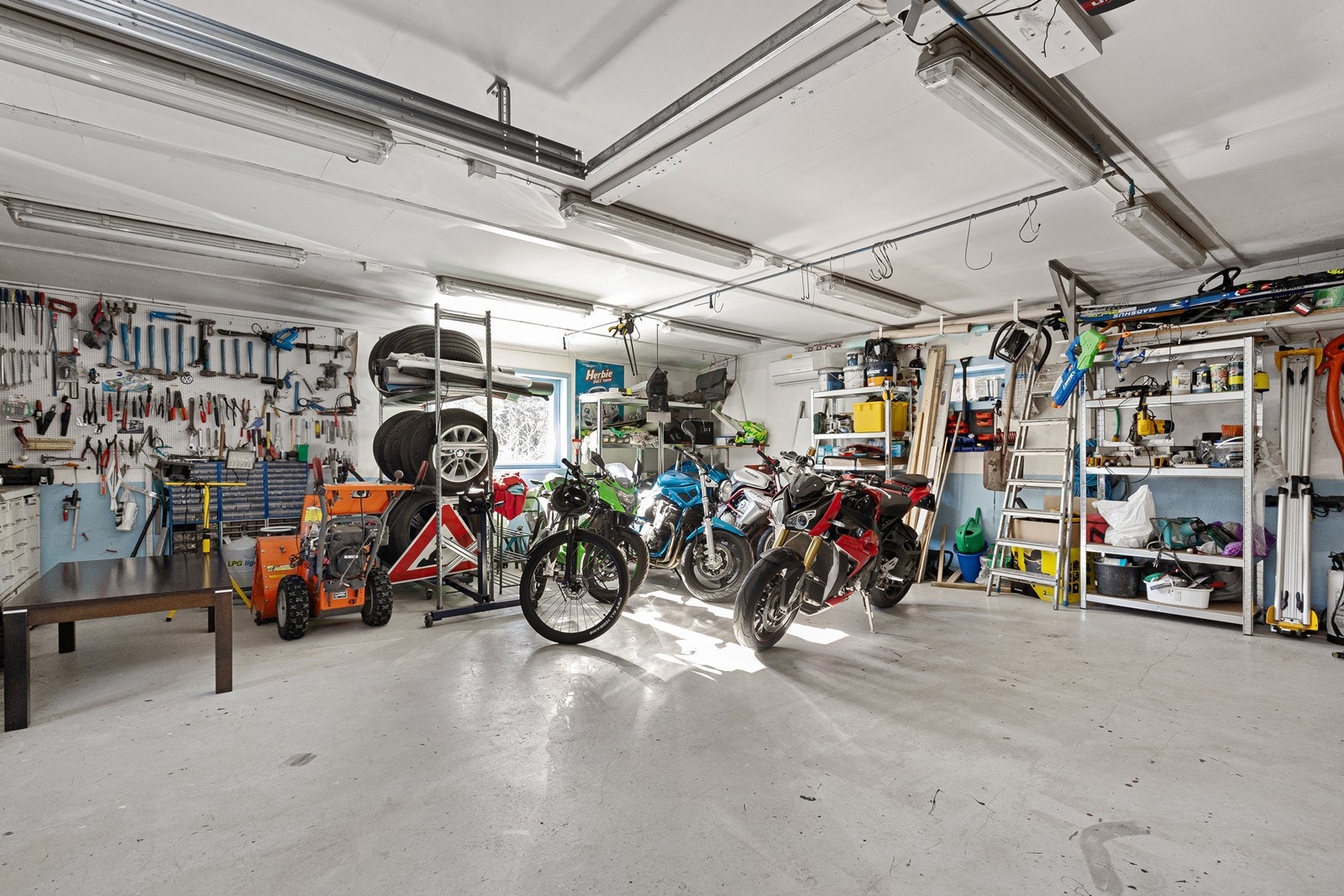 Garasjen har støpt og malt betongplate med varmekabler, og er utstyrt med en motorisert leddport i aluminium fra 2023. Galleribilde