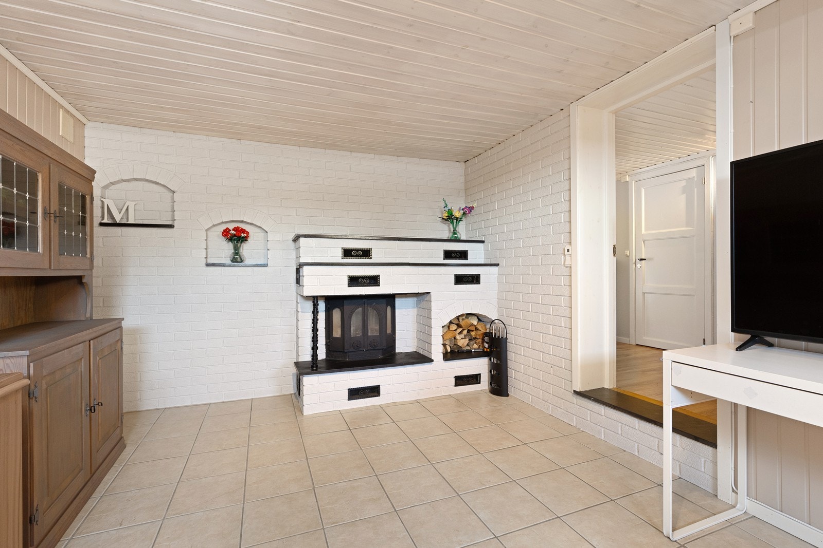 Peis med innsats i kjelleren gir en koselig varmekilde i rommet. Galleribilde