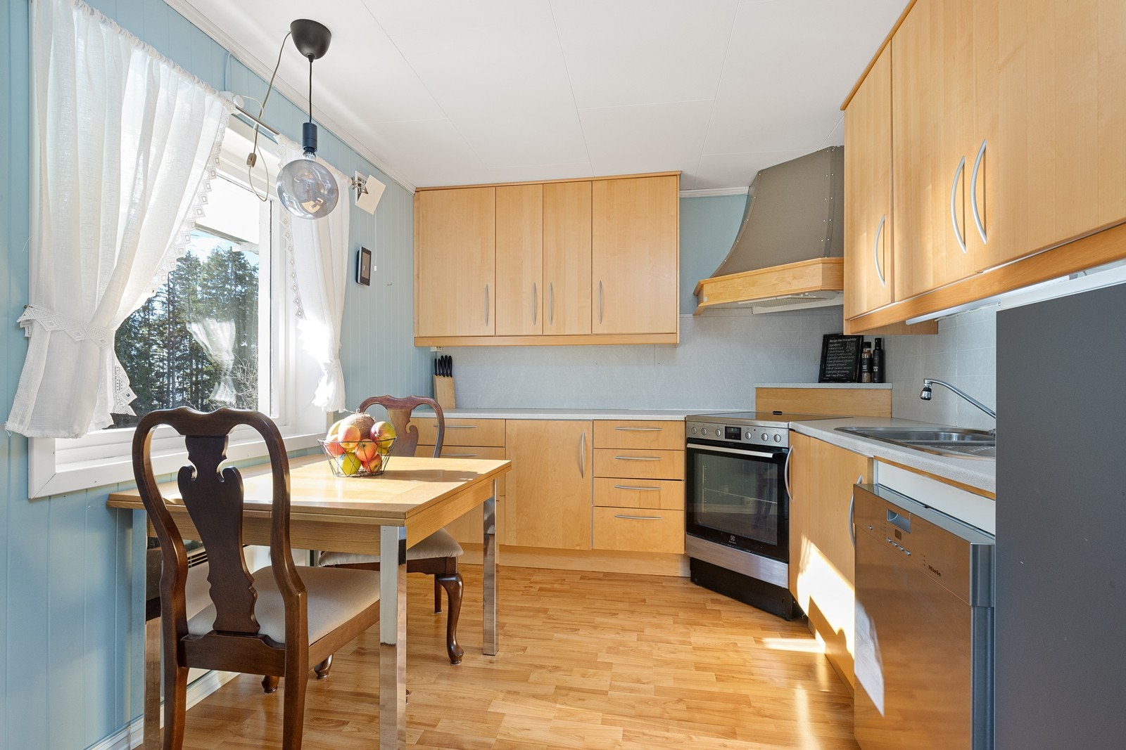 Kjøkkenet har en L-formet innredning med bjørkefronter og laminert benkeplate, samt ventilator fra Røroshetta. Galleribilde