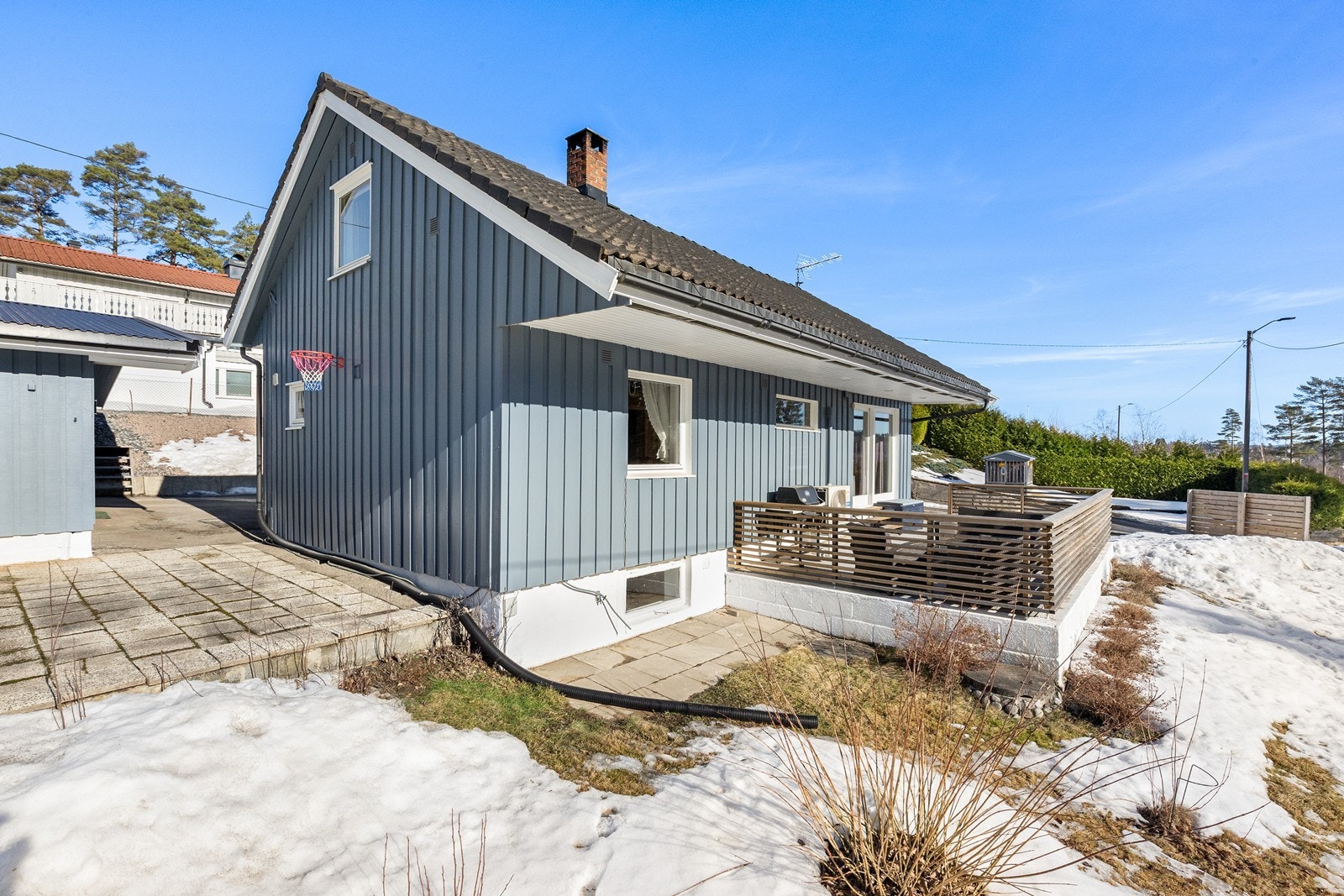 Huset har en veranda med fliser på 60x60 cm og rekkverk med spiler. Galleribilde