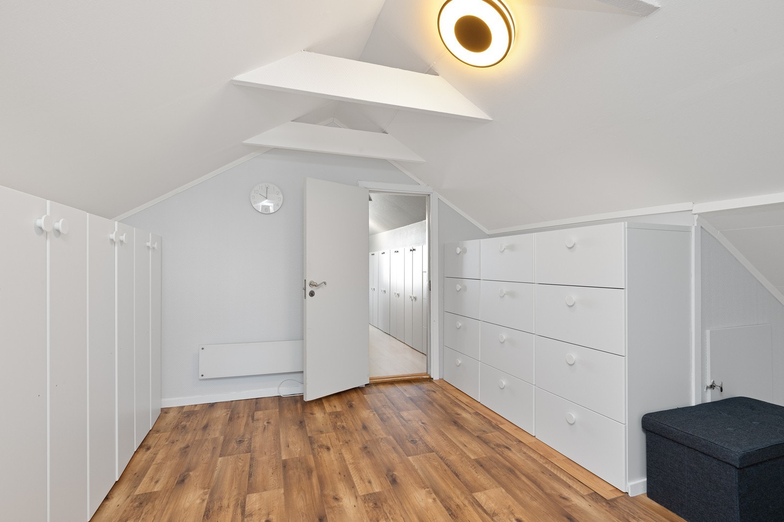 Garderobeløsning med hvite skap gir god oppbevaringskapasitet i rommet. Galleribilde