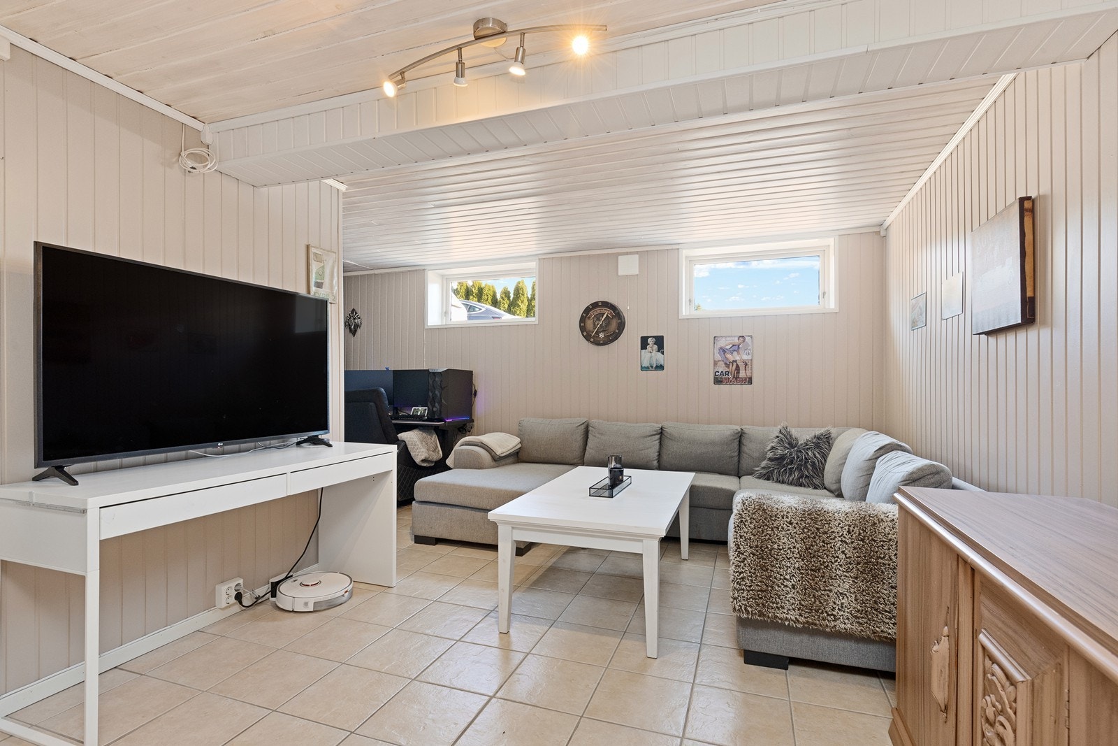 Store vinduer slipper inn naturlig lys i kjellerstuen, som har flislagt gulv. Galleribilde