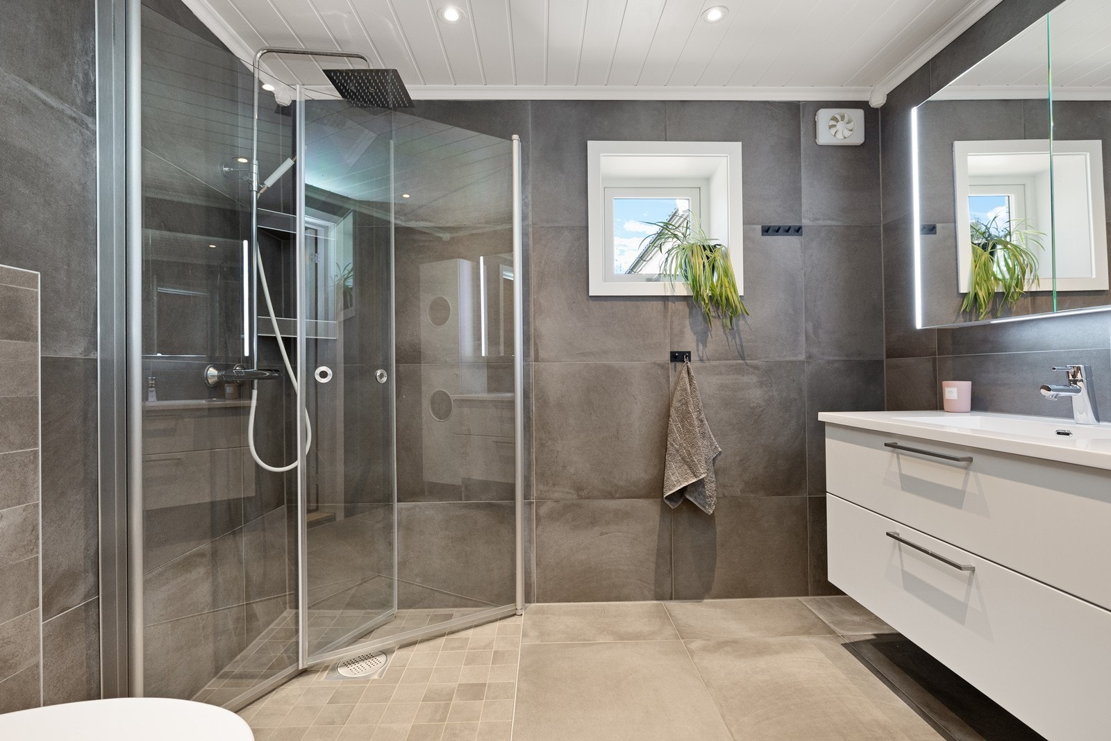 Dusjhjørne med glassdører og elektrisk vifte sikrer god ventilasjon. Galleribilde