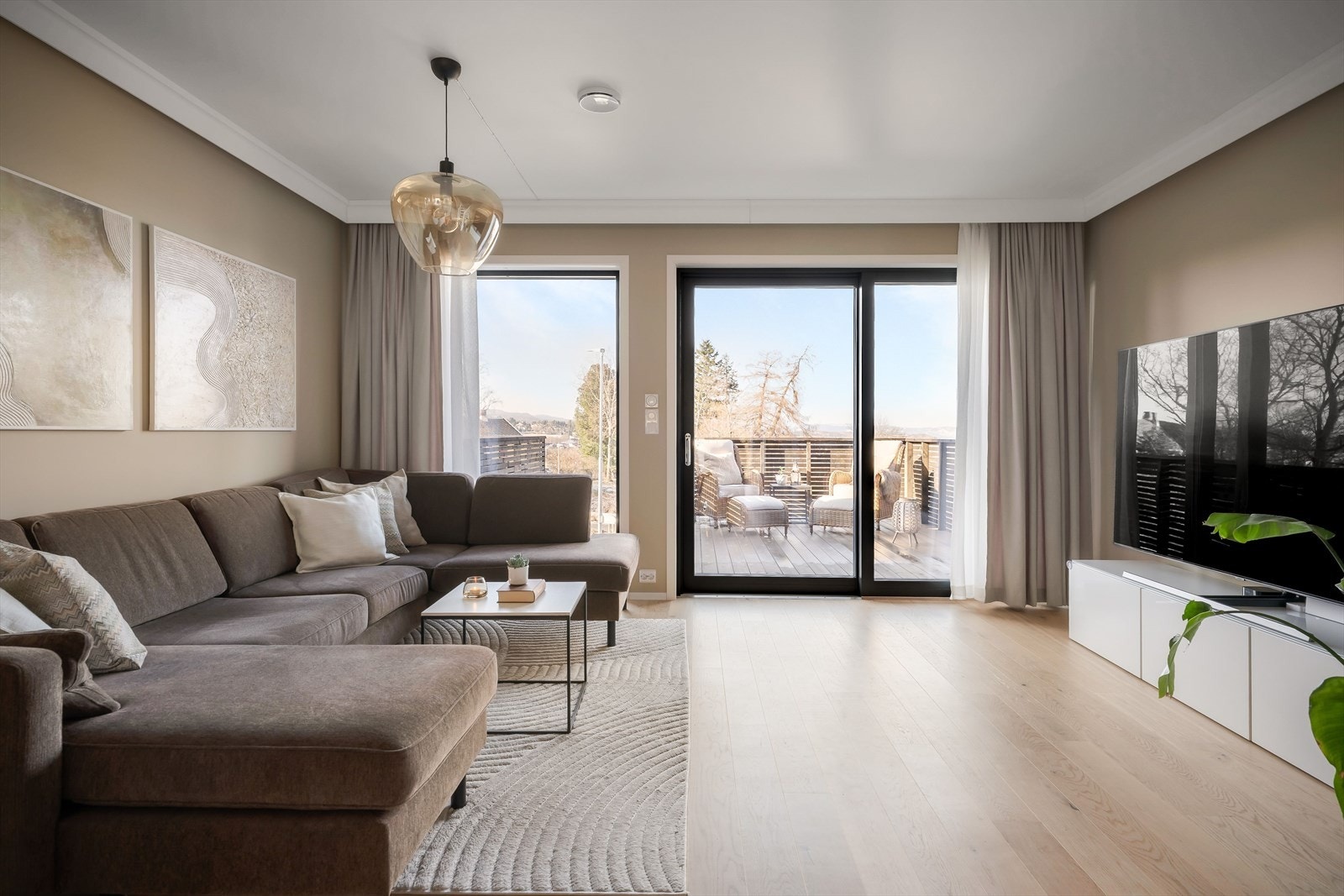 Fra underetasjen går trappen opp til første etasje hvor man finner en romslig og åpen stue- og kjøkkenløsning målt til hele 44 kvm! Galleribilde