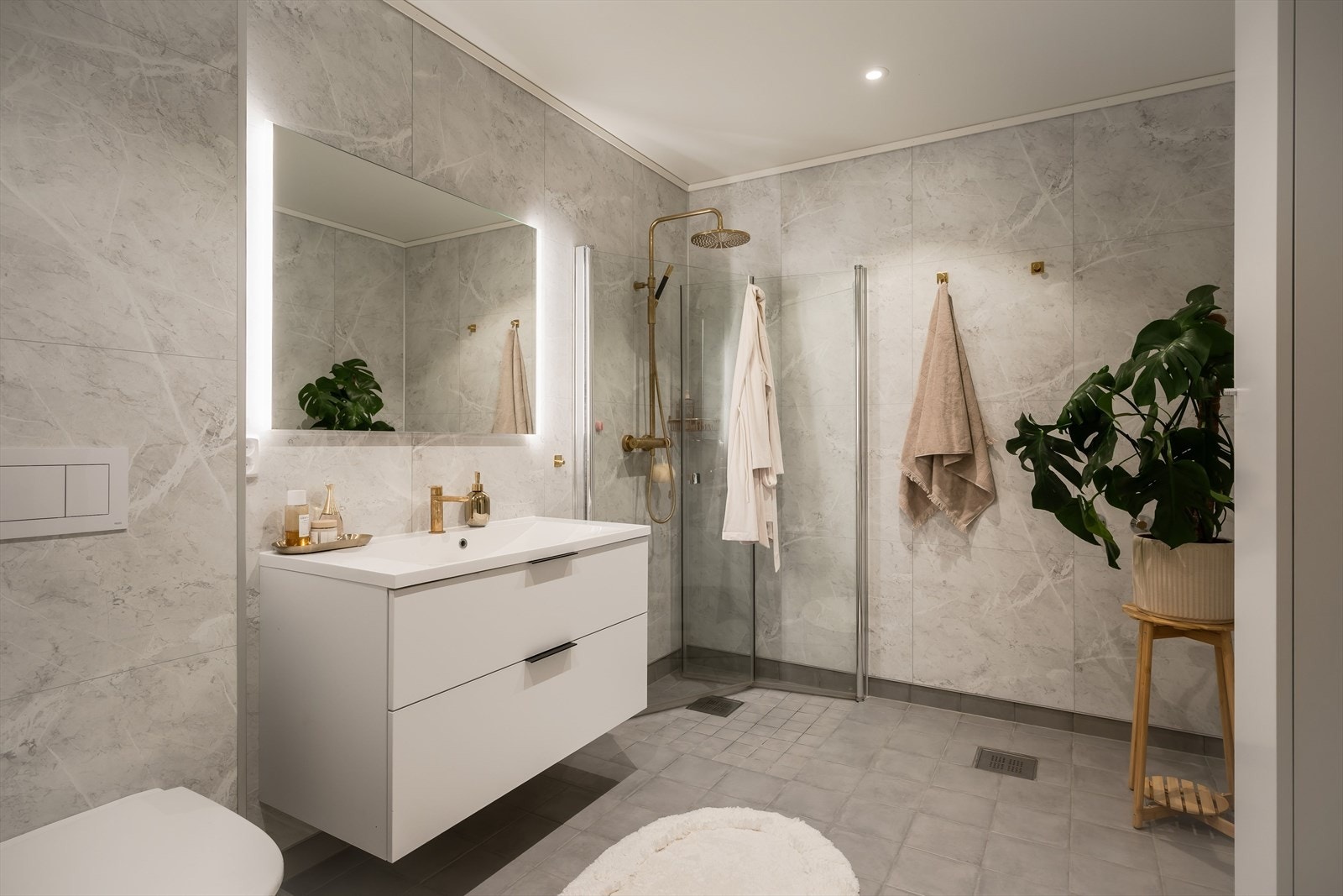 Badet i underetasjen er helfliset med gråtonede fliser på både vegger og gulv, og er utstyrt med varmekabler i gulvet. Galleribilde