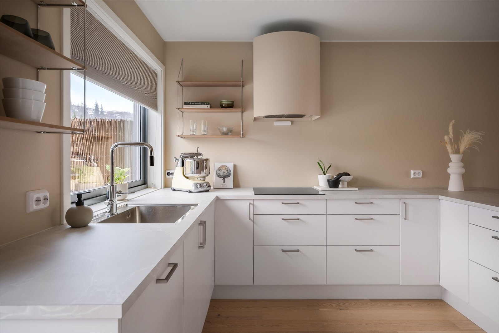 Kjøkkenet har klassiske hvite fronter kombinert med en lys grå benkeplate. Galleribilde