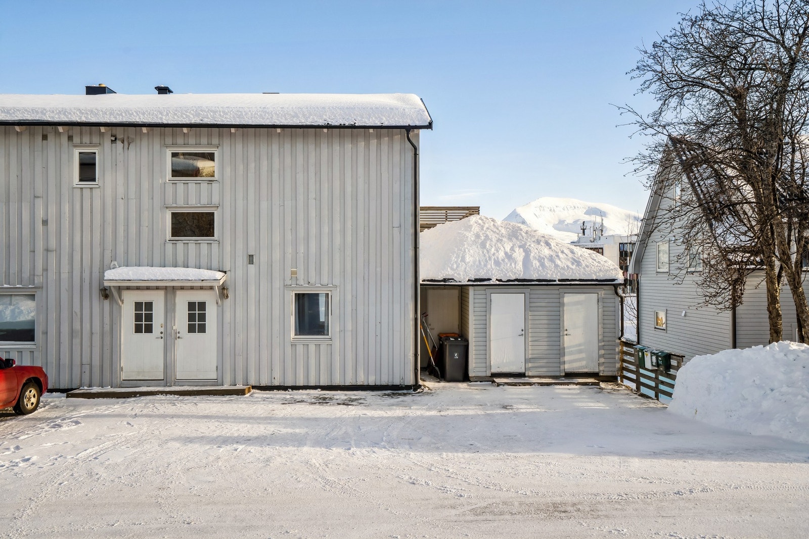 Parkering foran inngang. Boligen har også en sportsbod på sørsiden av bygget. Galleribilde