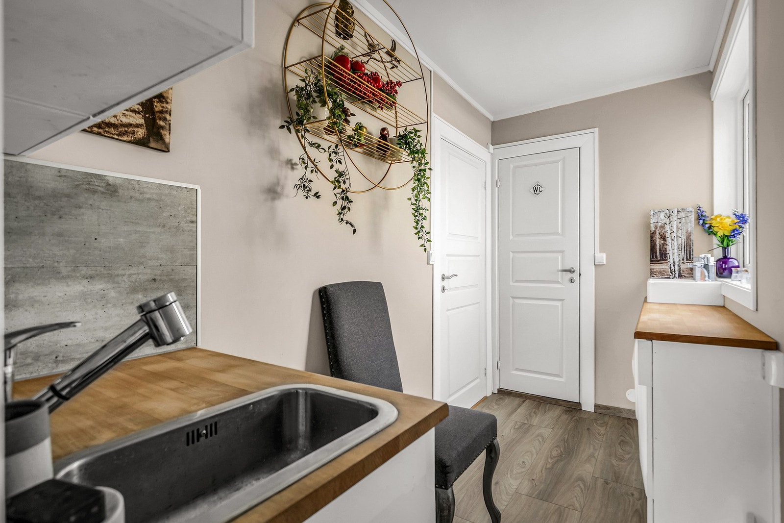 På veien til garasjen finner vi et minikjøkken med vindu og et lite bad med toalett, servant og dusj. Galleribilde