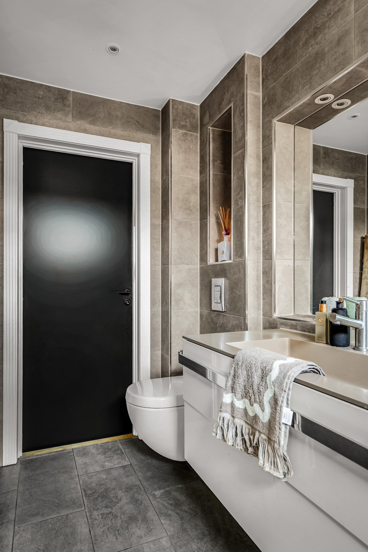 Badet er også innredet med bred servant med innfelt hylle og speil i veggen. Malt tak med downlights. Vegghengt toalett med plassbygget hylle. Rommet er ventilert. Galleribilde