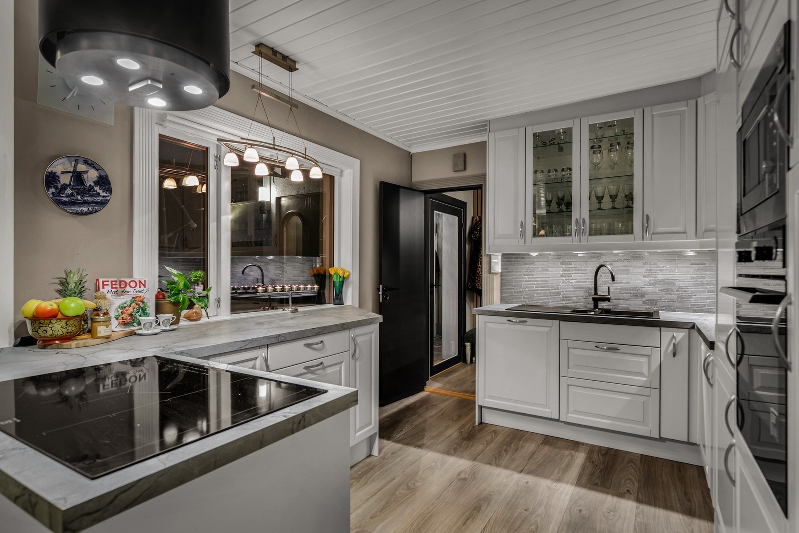 Pent kjøkken fra 2014 med hvite profilerte fronter. Her er det rikelig med skap og benkeplass. Galleribilde