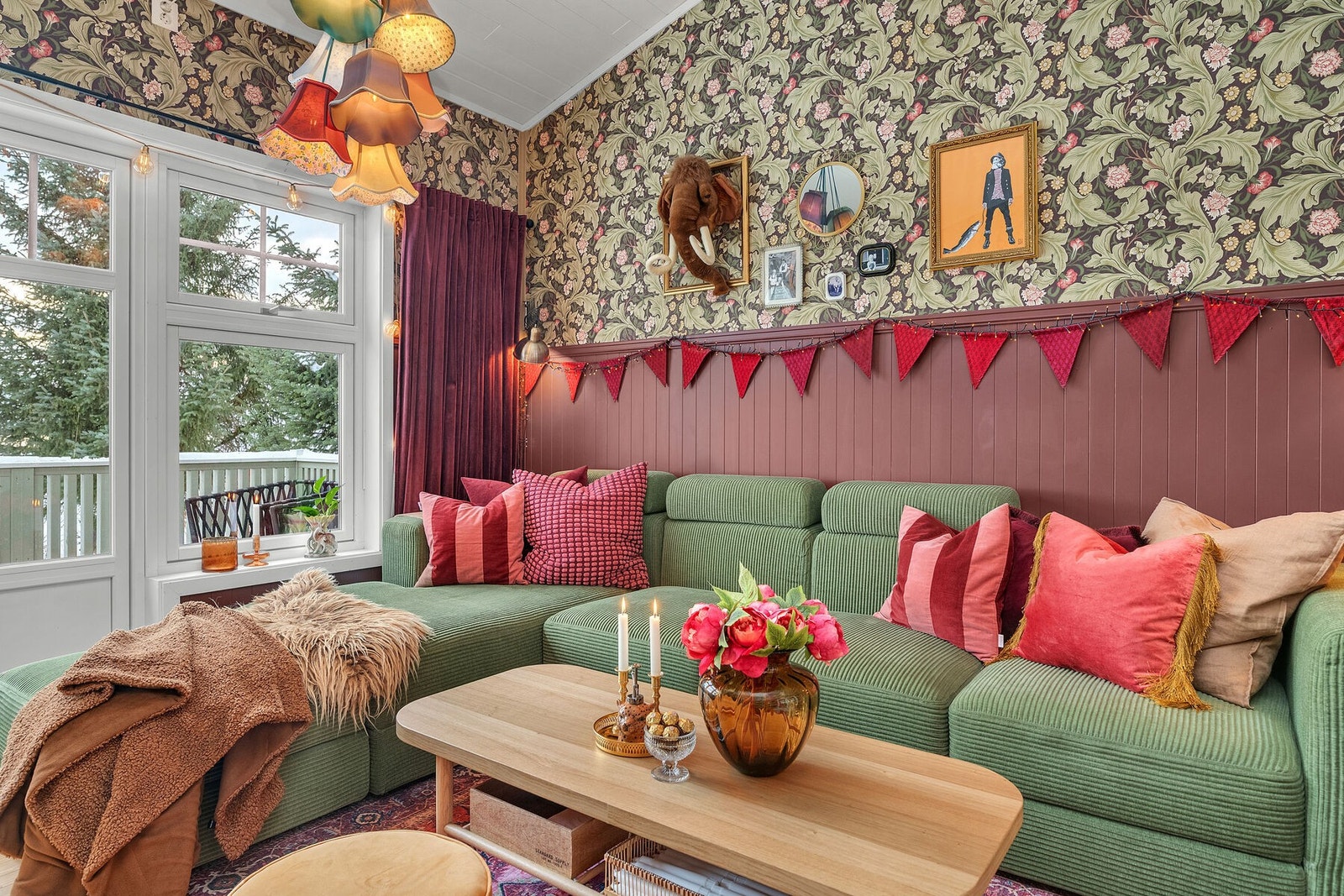 Fargerik tapet i kombinasjon med malt brystpanel gir stuen et personlig uttrykk. Galleribilde