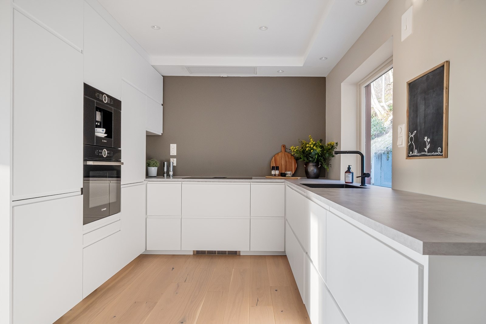 Behagelig fargevalg på kjøkkenet med "Gentle Whisper" i fin kombinasjon med "Soft Comfort" på kortveggen. Galleribilde