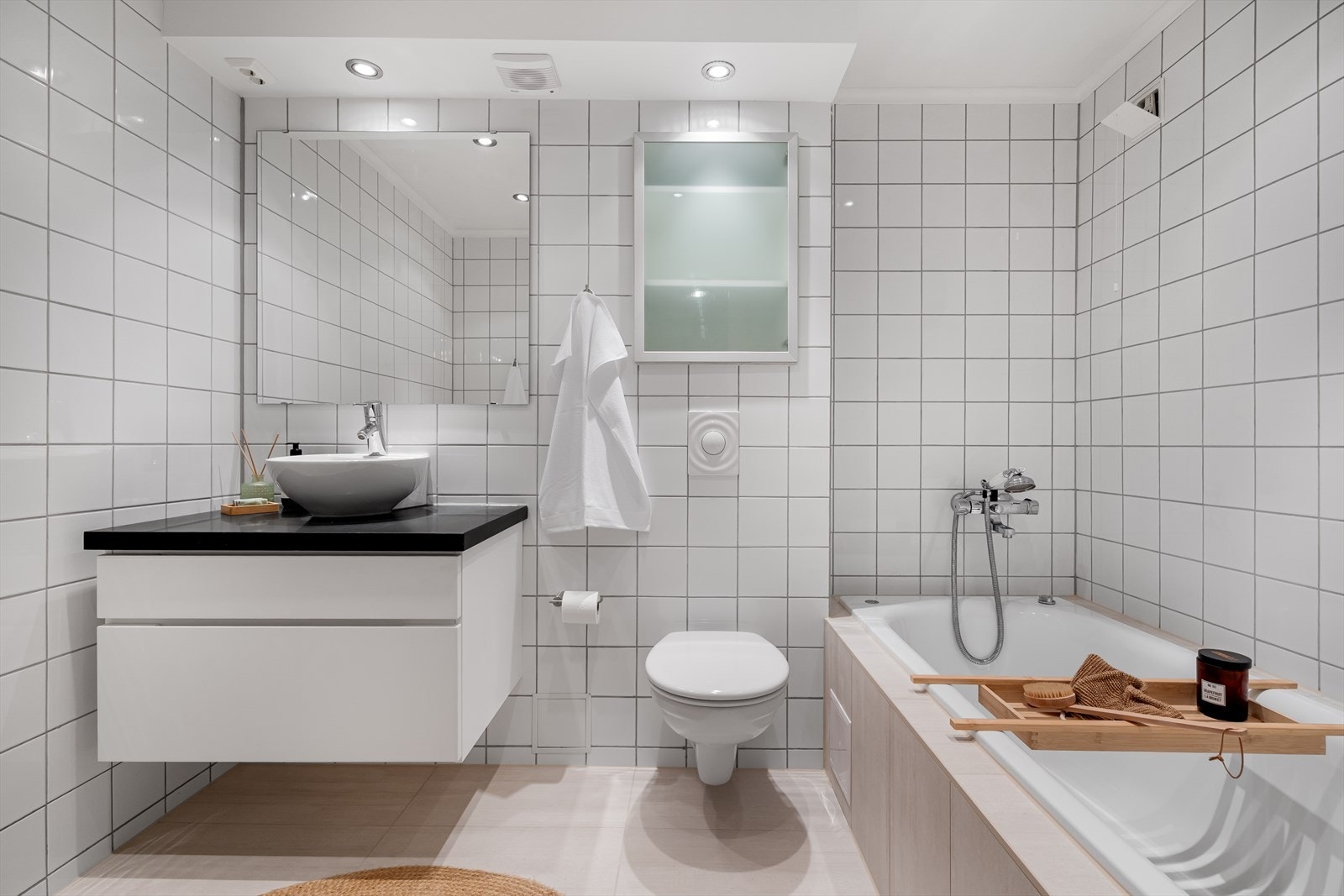 Badet i underetasjen har delikate flislagte overflater og innfelte downlights i himlingen Galleribilde