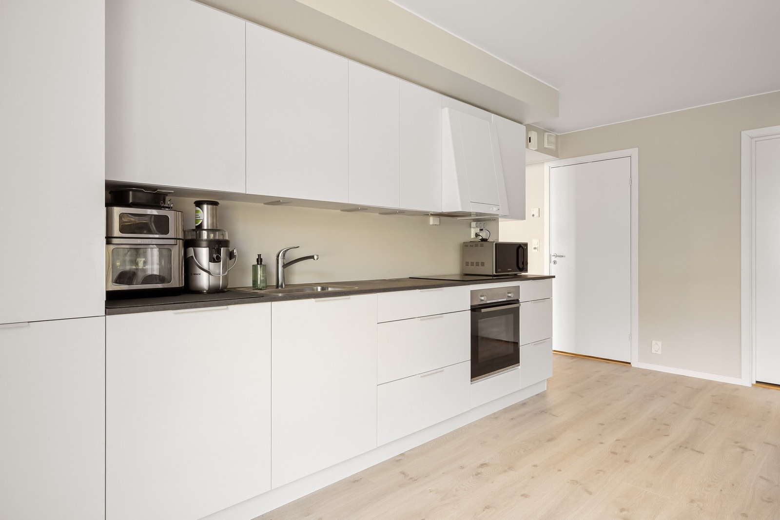 Kjøkkenet består av slette fronter og benkeplate av laminat, og er utstyrt med følgende integrerte hvitevarer: Stekeovn, platetopp, oppvaskmaskin og kjøleskap med fryser. Galleribilde