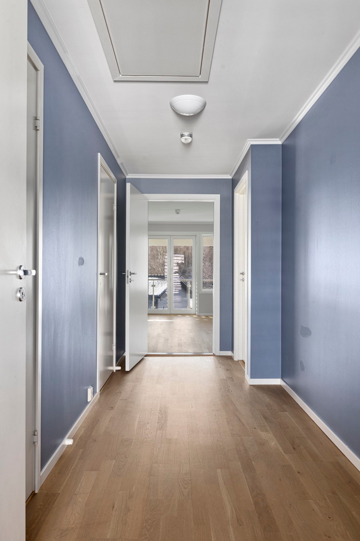 Gang med blåmalte vegger som gir rommet et særpreg. Galleribilde