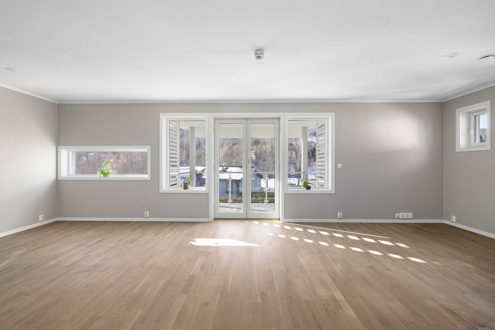 Solrik og romslig stue med store vindusflater og utgang til balkong. Galleribilde