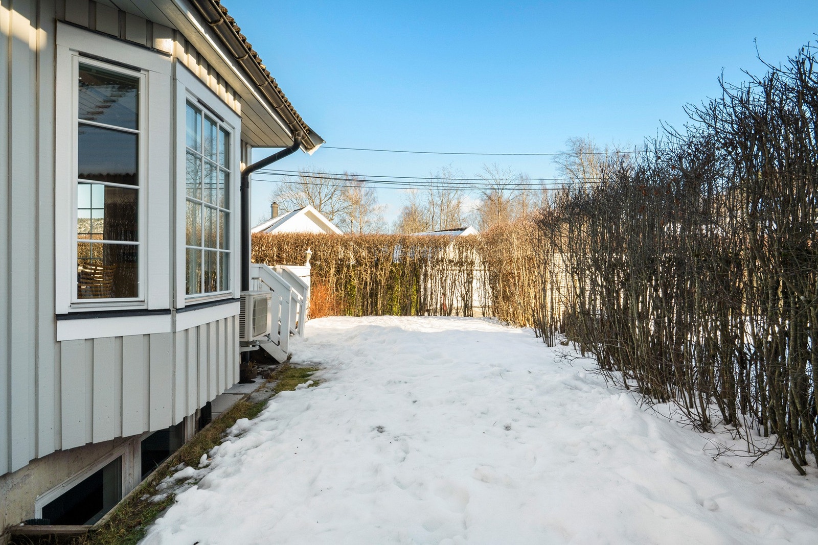 Terrassen har adkomst til hagen som strekker seg rundt hele boligen Galleribilde