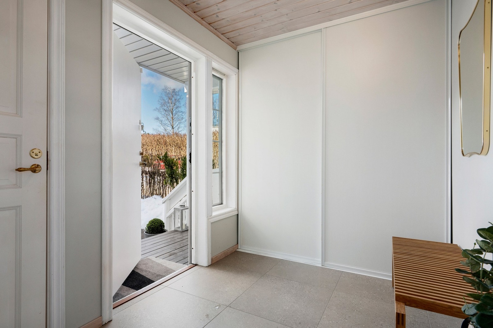 Entréen har praktiske fliser på gulv og en større skyvedørsgarderobe med god plass til yttertøy og sko Galleribilde