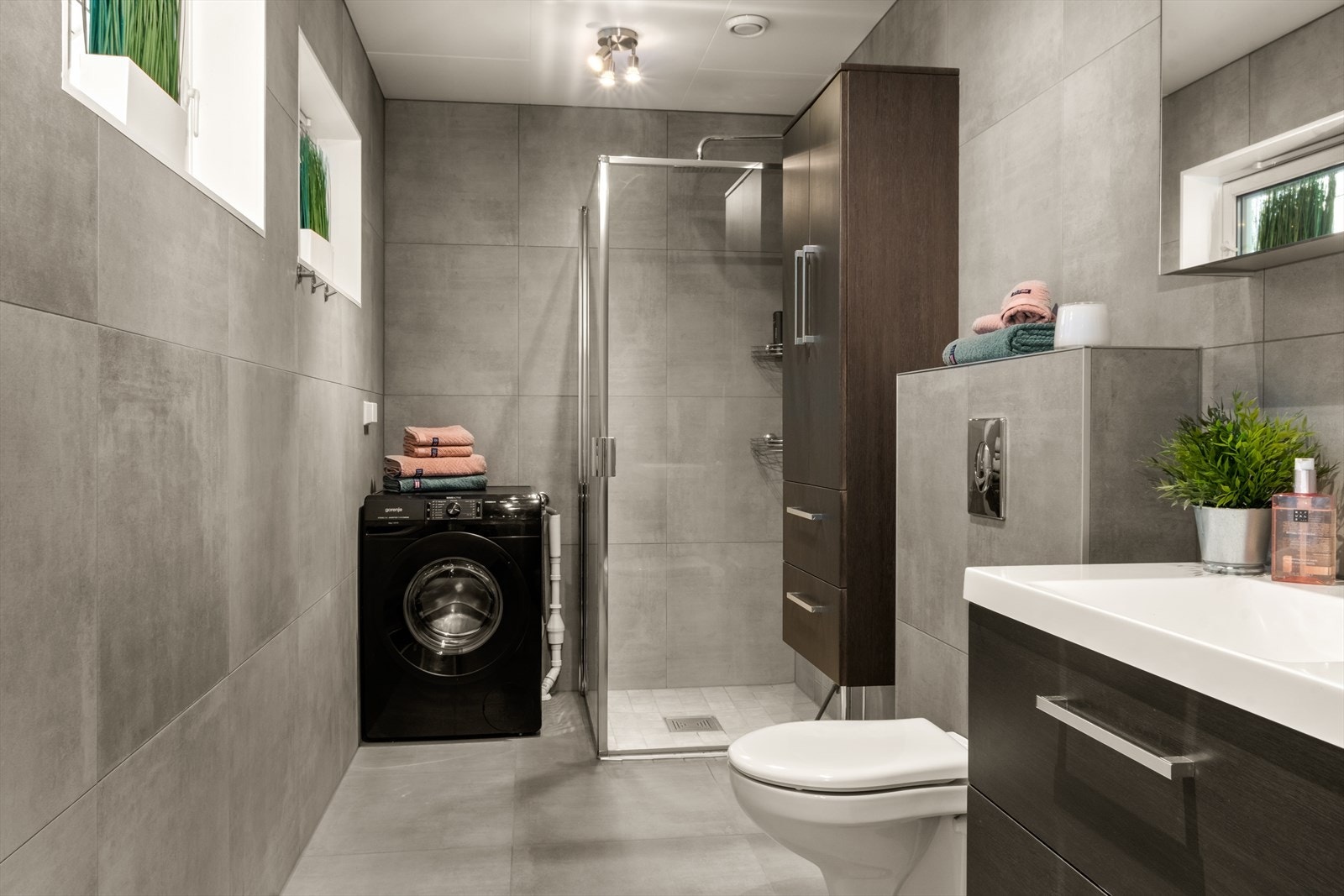 Badet nede er lekkert flislagt i mørkegrått. Brun innredning passer fint, ikke sant ? Galleribilde