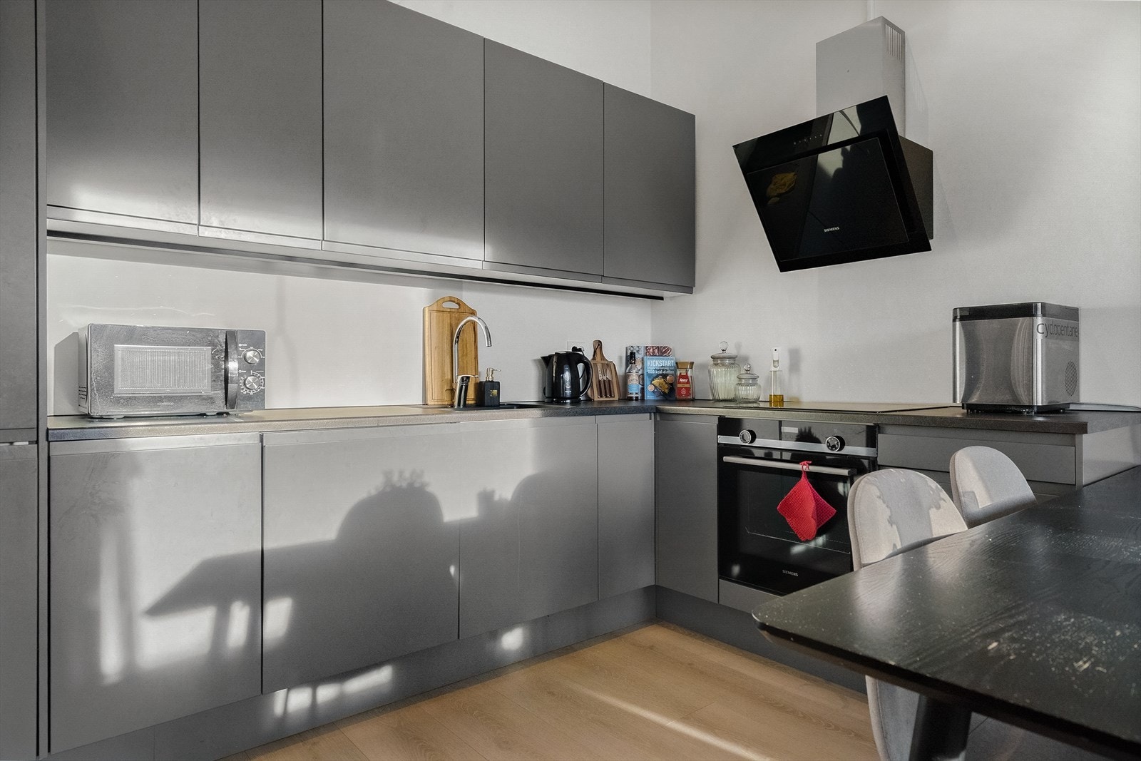 Strøkent kjøkken innredet med kjøl/fryseskap, oppvaskmaskin, stekeovn, vannstoppsystem og komfyrvakt. Galleribilde