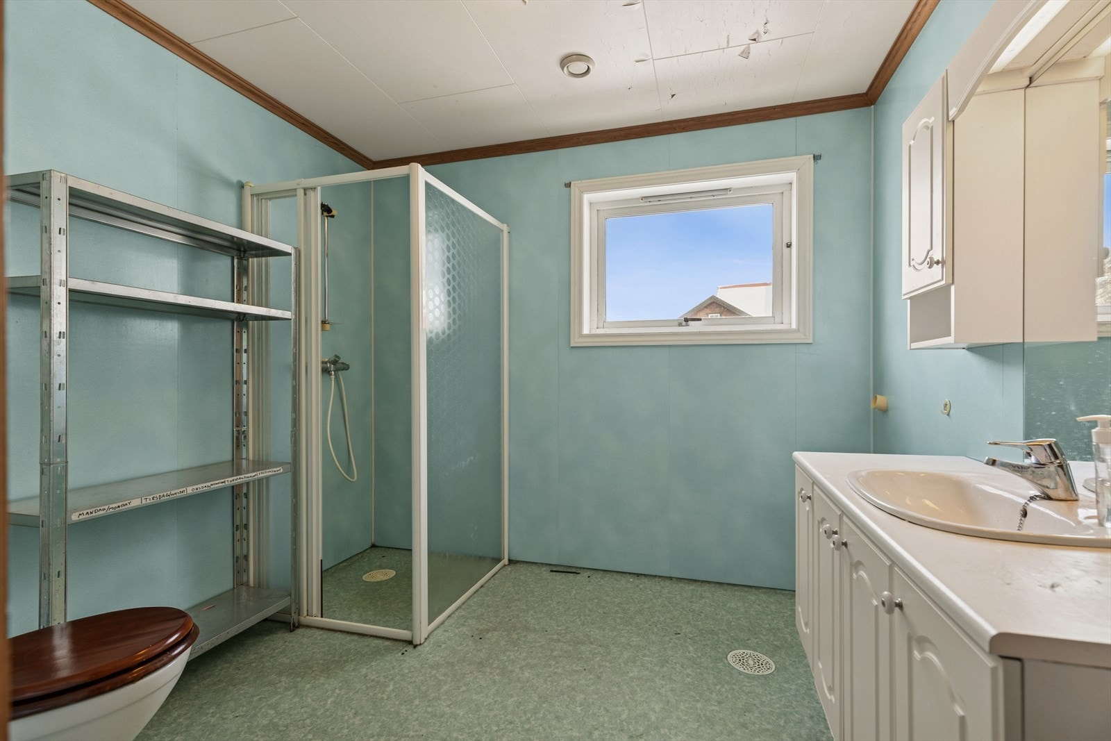 Badet i 1. etasje har belegg på gulv og våtromsplater på vegg. Innehar dusjhjørne, toalett og innredning med under- og overskap. Galleribilde