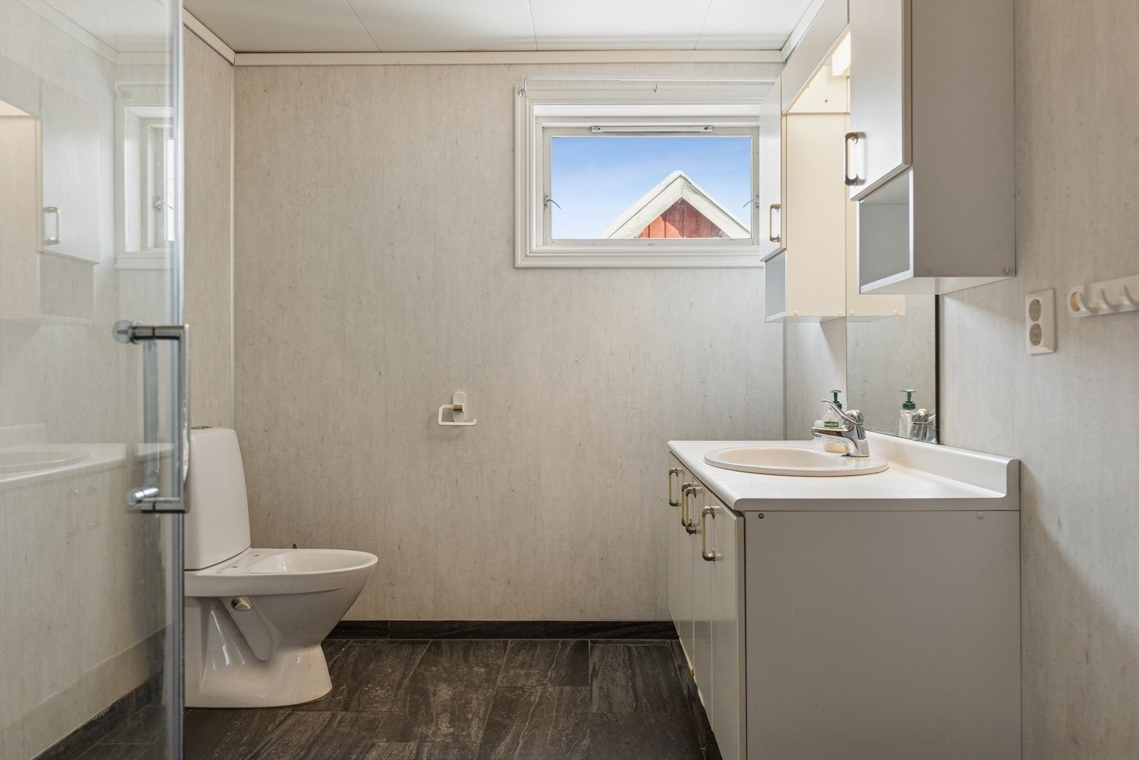 Badet i kårboligen har flislagt gulv og våtromsplater på vegg. Det er montert skapinnredning, dusjhjørne, toalett og oppl. for vaskemaskin. Galleribilde