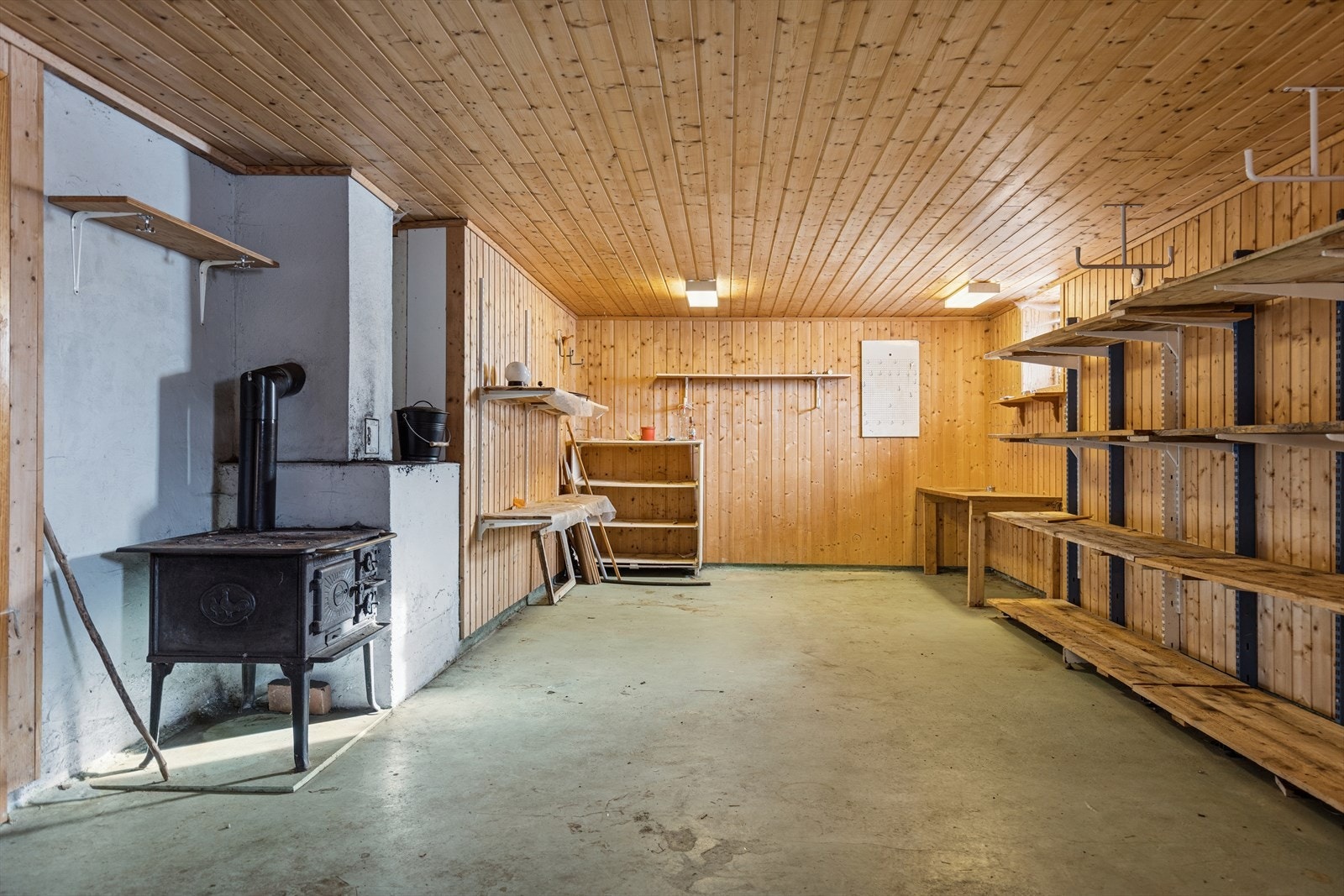 I det store lagerrommet er det montert praktiske hyller og en vedovn med kokeplater. Galleribilde