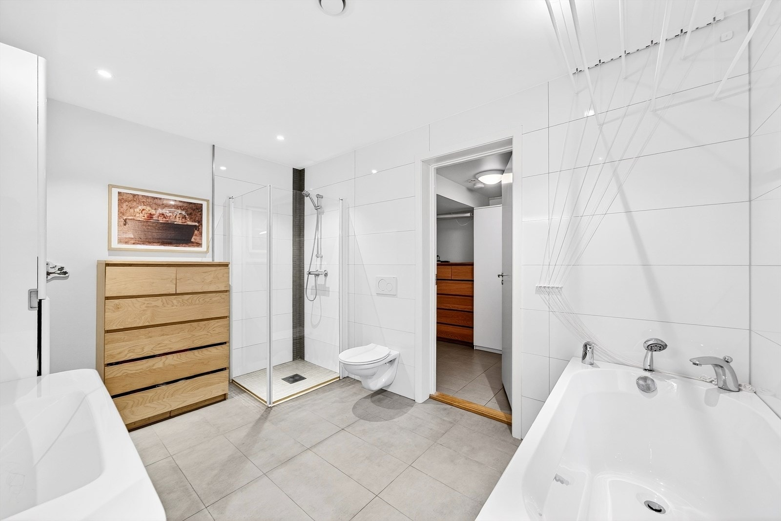 Bad i 1. etg med dusjhjørne, badekar og flislagt gulv med varmekabler. Galleribilde