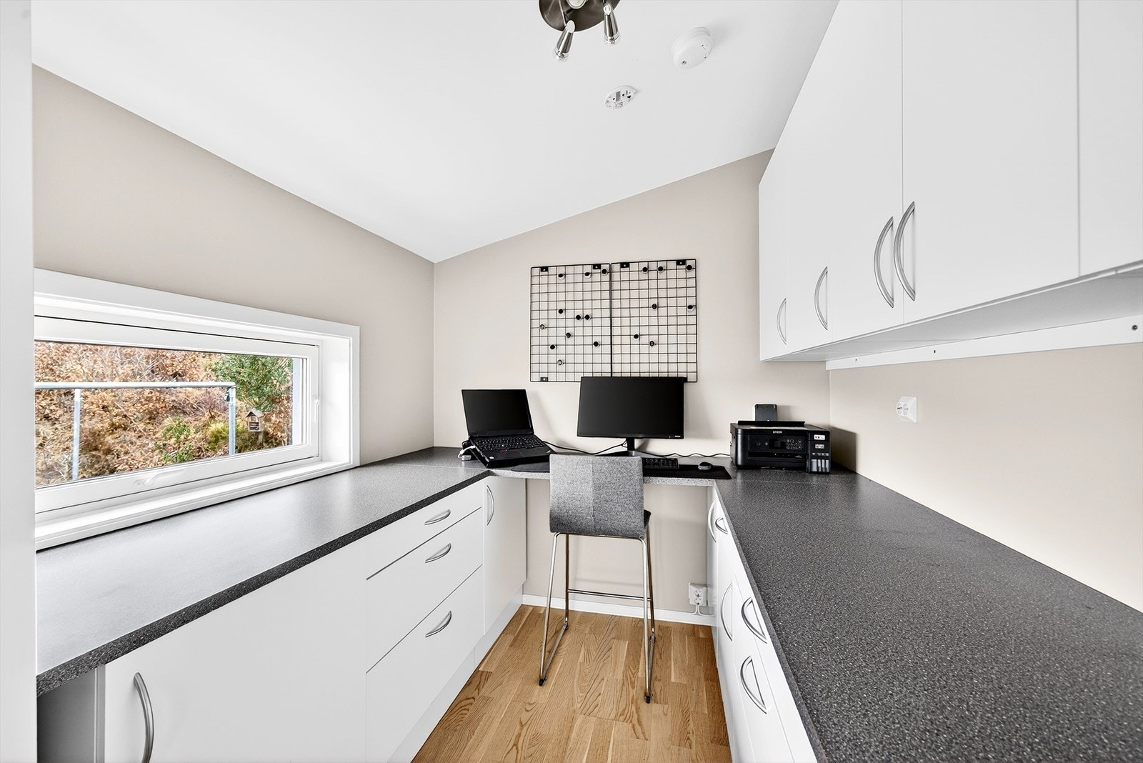 Kontor/grovkjøkken - kjøkkeninnredning fra Aubo, som også inneholder 2 store sokkelskuffer, robotstøvsuger-garasje i sokkel, og utfellbart strykebrett. Galleribilde