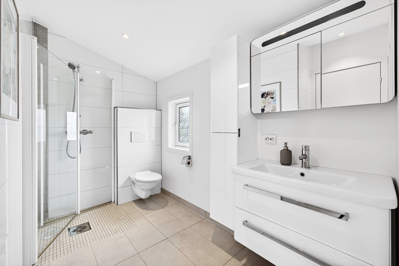 Bad i 2. etasje med flislagt gulv med varmekabler, vegghengt wc, dusjhjørne og moderne baderomsinnredning. Galleribilde