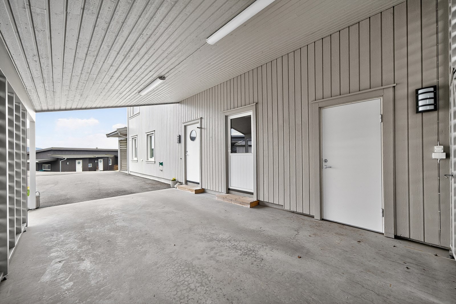 Romslig carport med inngang til entre, vaskerom og bod. Galleribilde