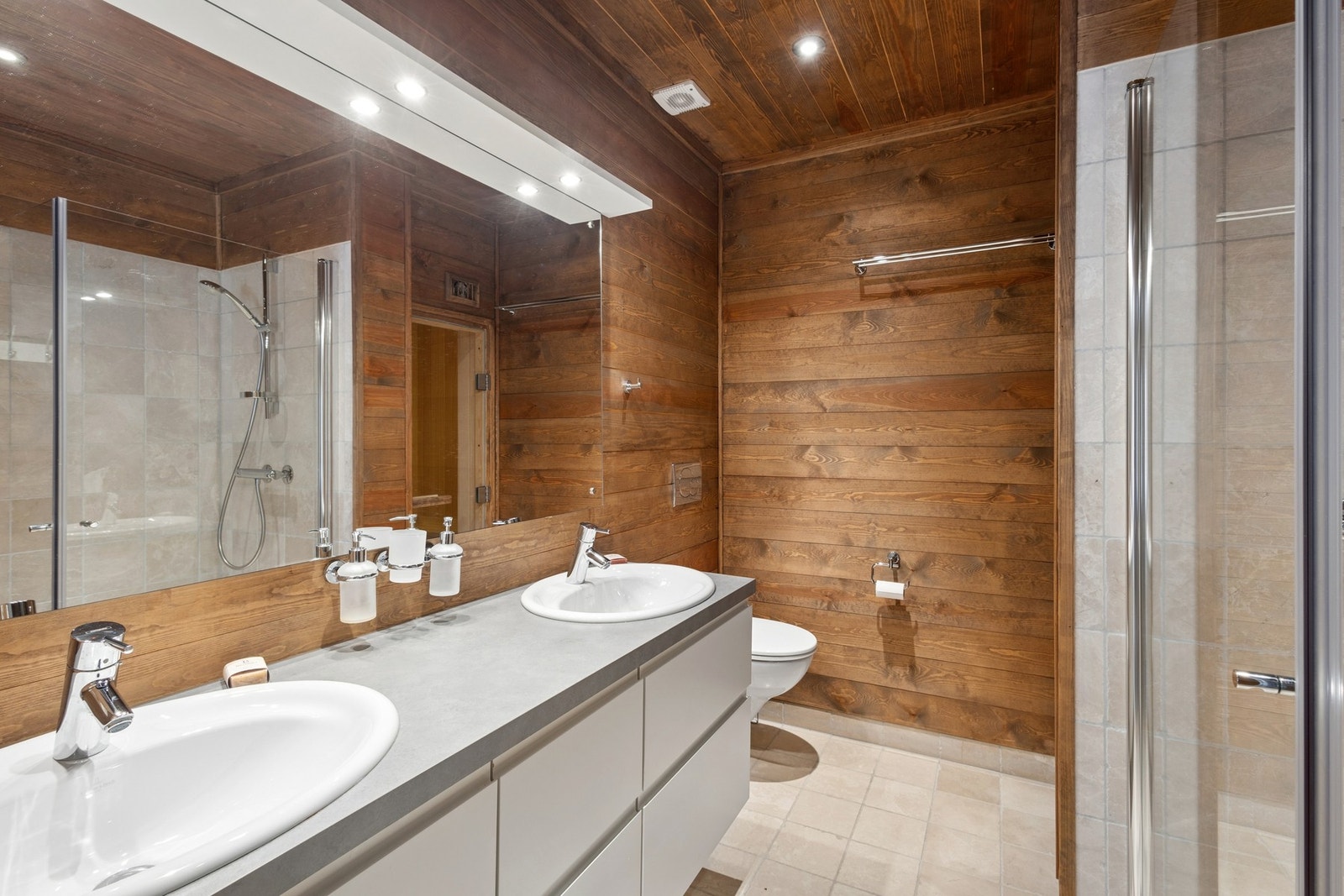 Badet er innredet med en 160 cm bred baderomsinnredning med glatte fronter, benkeplate og to nedfelte servanter. Galleribilde