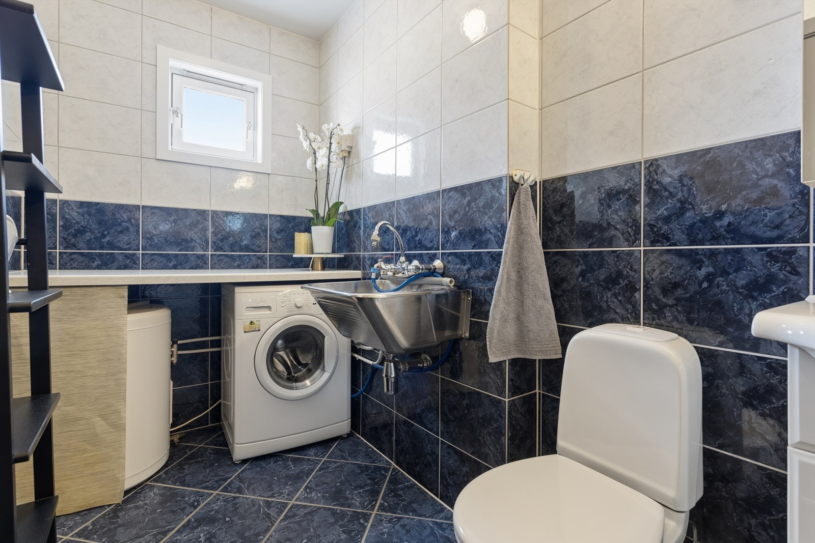 Badet er lyst og har fliser på både gulv og vegger. Her har du og opplegg for vaskemaskin Galleribilde