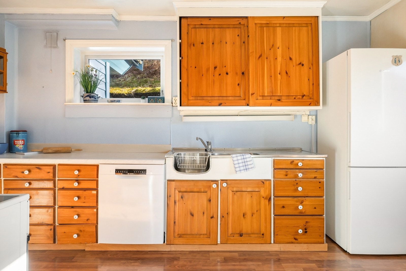 Eldre kjøkkeninnredning med profilerte fronter og laminert benkeplate Galleribilde