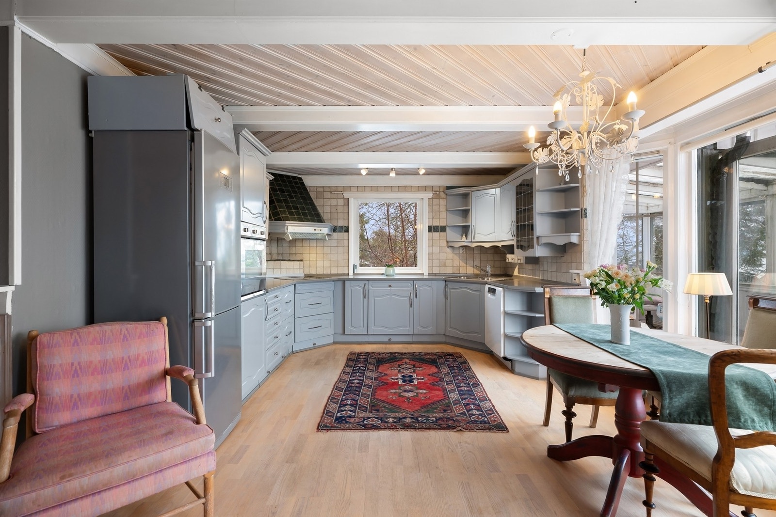 Malt profilert innredning med laminat benkeplater nedfelt vaskekum, fliser over benker. Galleribilde